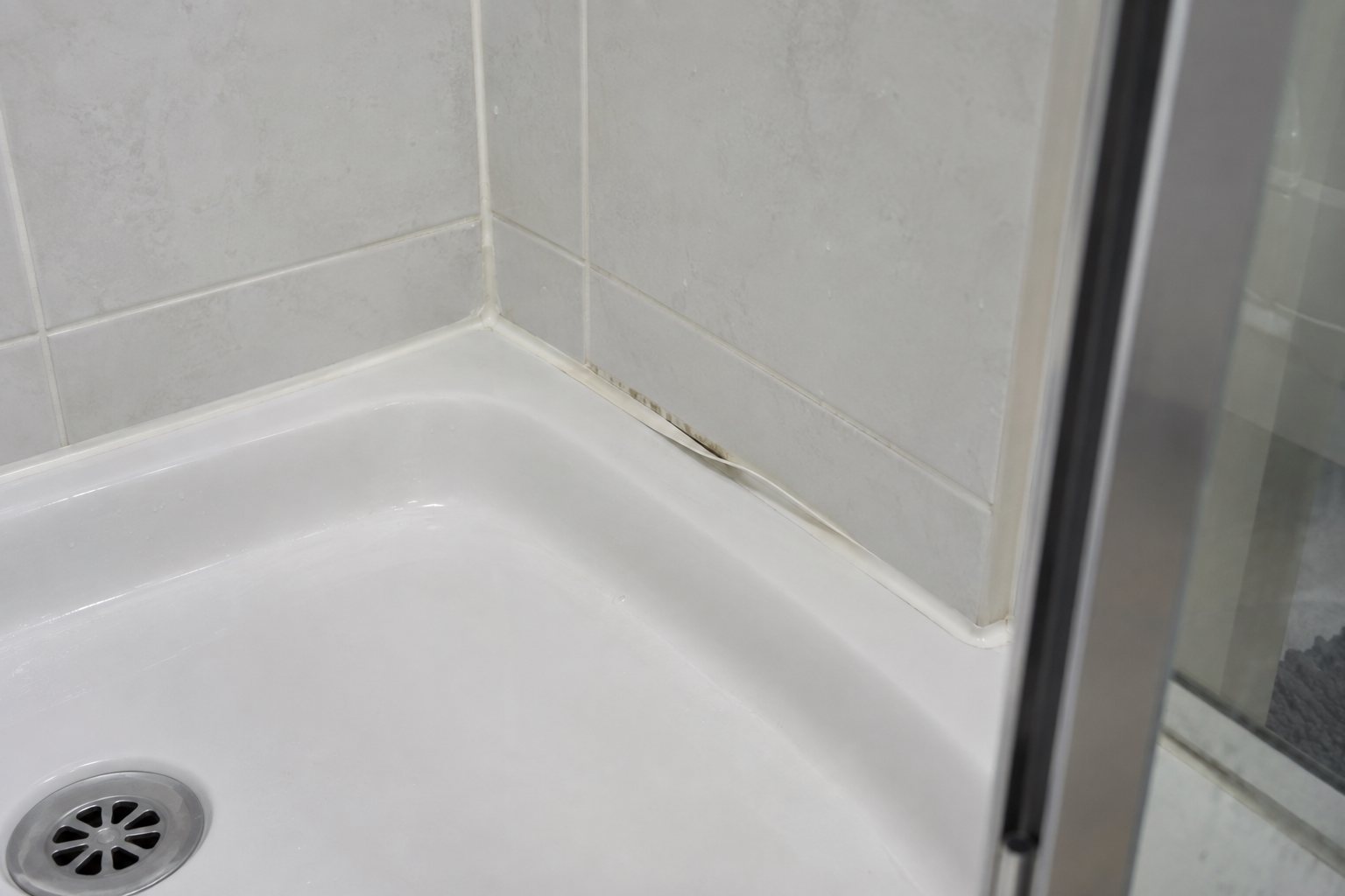 Close-up of a lifting shower seal in a fictional rental bathroom